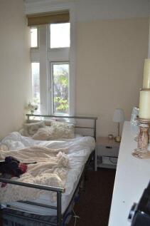 A cozy bedroom featuring a metal bed frame, a w...