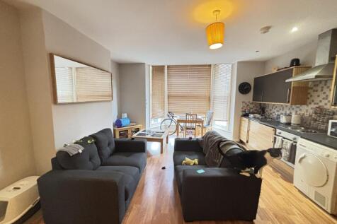 A spacious, modern living room featuring comfor...