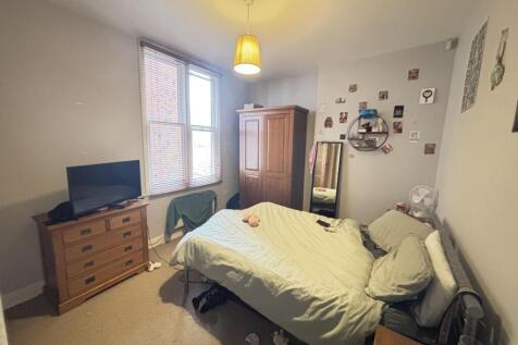 A spacious and bright master bedroom featuring ...