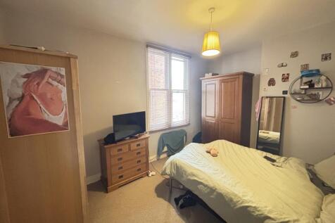 A spacious and well-lit bedroom featuring a lar...