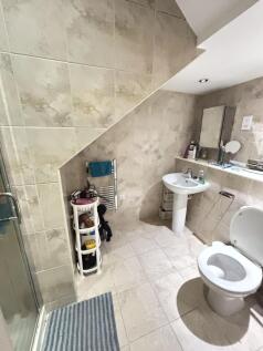Well-maintained bathroom featuring a shower, to...
