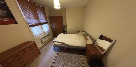 A cozy single bedroom featuring a double bed, w...