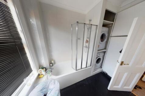 A bright and clean bathroom with a large shower...