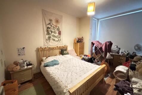 A cozy bedroom featuring a well-made bed, a woo...