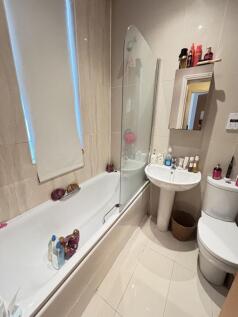 A clean and modern bathroom featuring a bathtub...