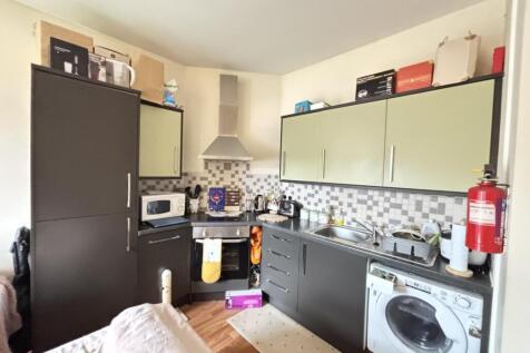 A modern kitchen area featuring a sleek grey an...