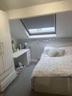 A cozy and bright bedroom featuring a large bed...