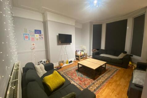 A spacious, well-lit living room featuring mode...