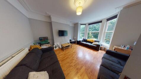 A spacious and well-lit living room featuring m...