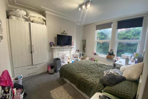 A cozy and well-lit bedroom featuring a large b...