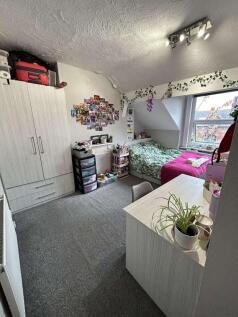 A cozy student bedroom featuring a single bed, ...