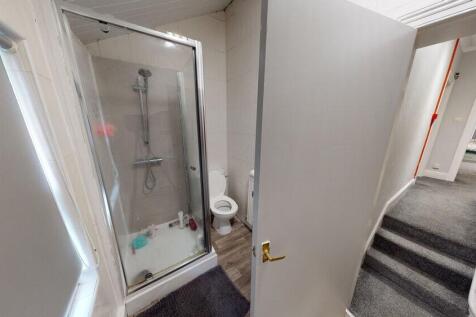 A bright, clean bathroom featuring a shower uni...