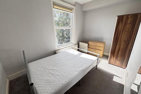 A bright and tidy bedroom featuring a single be...