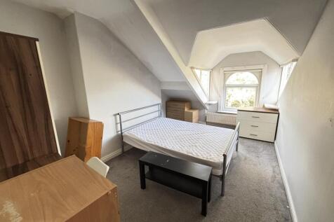 A bright, tidy bedroom with a large window allo...