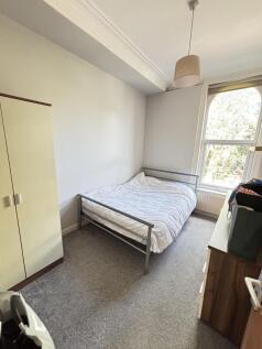 A bright and tidy bedroom with a comfortable do...