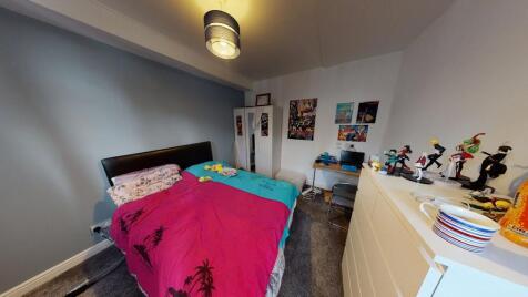 A cozy bedroom featuring a double bed with colo...