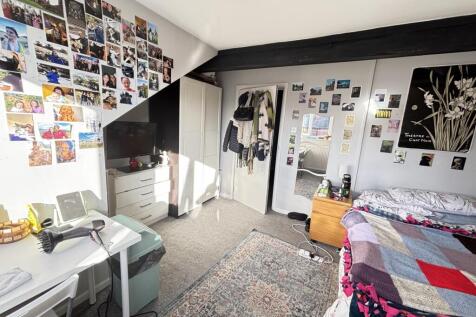 Spacious master bedroom featuring a large bed a...