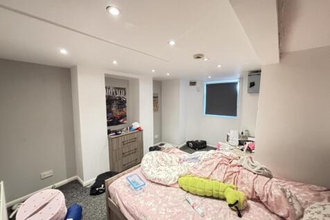 A well-lit bedroom featuring a double bed with ...