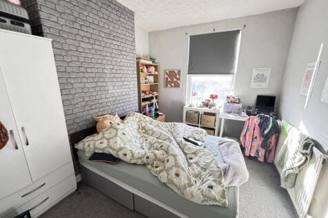 A cozy bedroom featuring a bed with plush beddi...