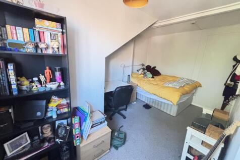 A cozy bedroom with a bed, some personal items,...