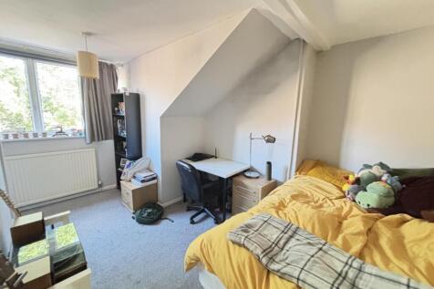 A cozy bedroom featuring a double bed with colo...