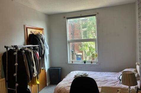 A cozy bedroom featuring a bed positioned near ...