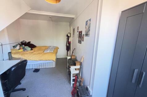 A modest bedroom featuring a double bed with a ...