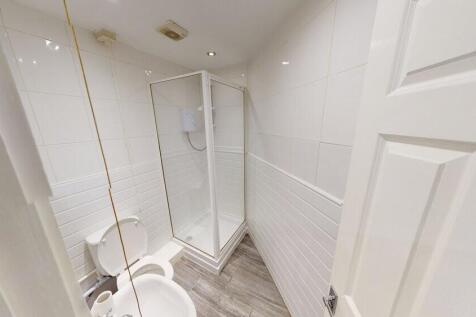 A clean, modern bathroom featuring a shower enc...