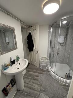 A modern bathroom featuring a compact shower en...