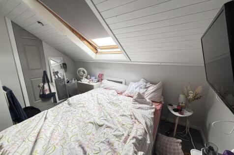 A spacious, well-lit master bedroom featuring a...