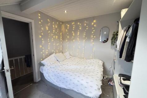 A bright and welcoming bedroom featuring a neat...
