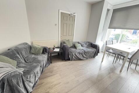 A bright, modern living room featuring comforta...