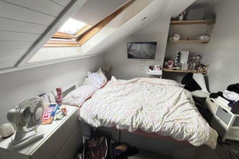 A spacious and bright bedroom featuring a large...