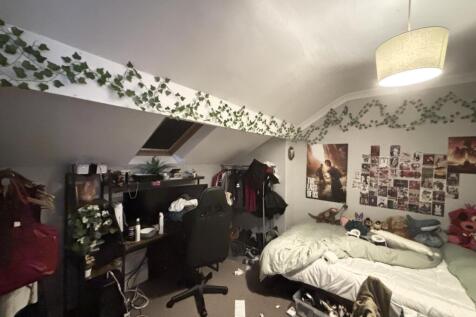 A cozy student bedroom featuring a bed and pers...