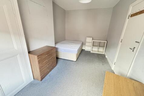 A simple, tidy bedroom with a single bed, a bed...