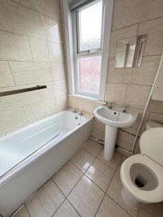Bright and clean bathroom featuring a bathtub, ...