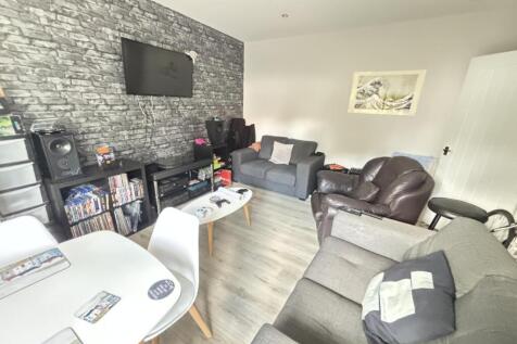 A spacious and well-lit living room featuring c...