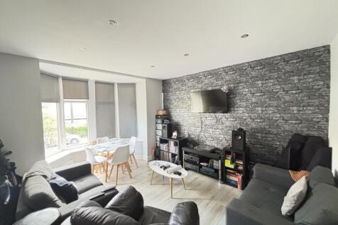 A bright, spacious living room featuring modern...