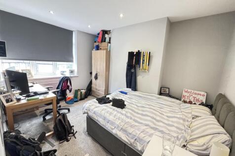 A cozy bedroom featuring a comfortable bed, a w...