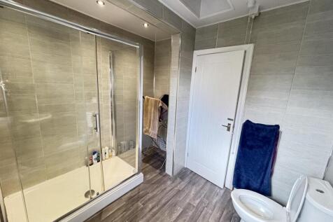 Clean and bright bathroom featuring a modern sh...