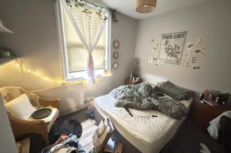 A cozy bedroom with a neatly made double bed, s...