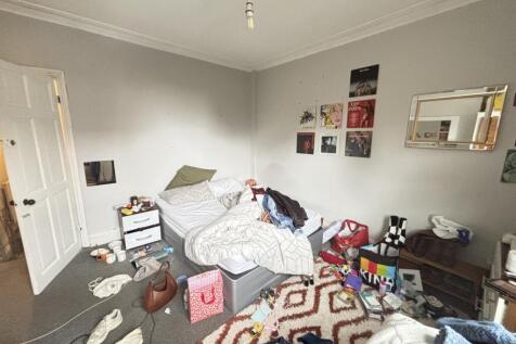 A casual living room with a sofa, cluttered sur...