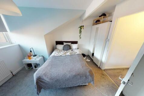 A spacious and well-lit master bedroom featurin...