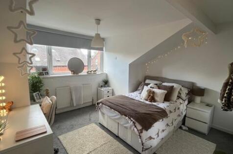 A spacious and well-lit master bedroom with a c...