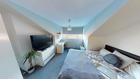 A spacious and modern master bedroom featuring ...