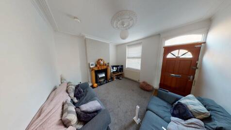 A spacious and well-lit living room featuring c...