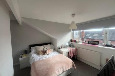 Bright and cozy master bedroom featuring a comf...