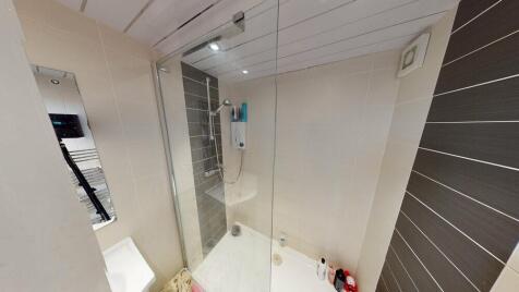A clean and well-lit bathroom with a spacious s...