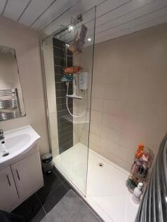 A modern and clean bathroom featuring a walk-in...