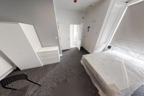 A bright and neat bedroom with natural light st...